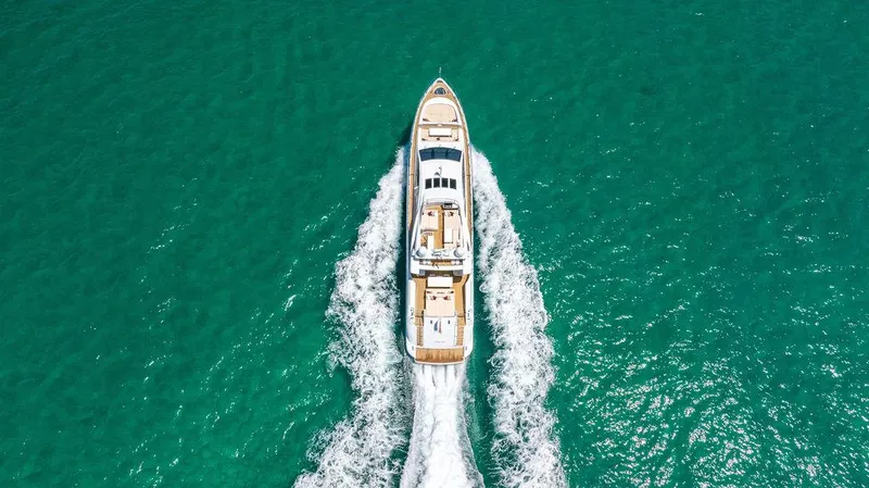 Mixed Emotions Yacht Photos Pics Aerial view of 2014 Mangusta 110 yacht cruising on turquoise waters.