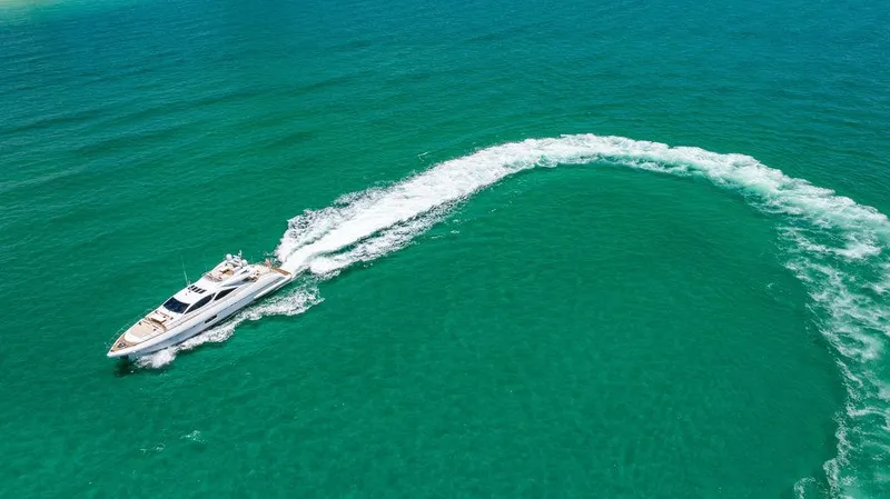 Mixed Emotions Yacht Photos Pics Luxurious 2014 Mangusta 110 yacht cruising in turquoise waters, leaving a curved wake.