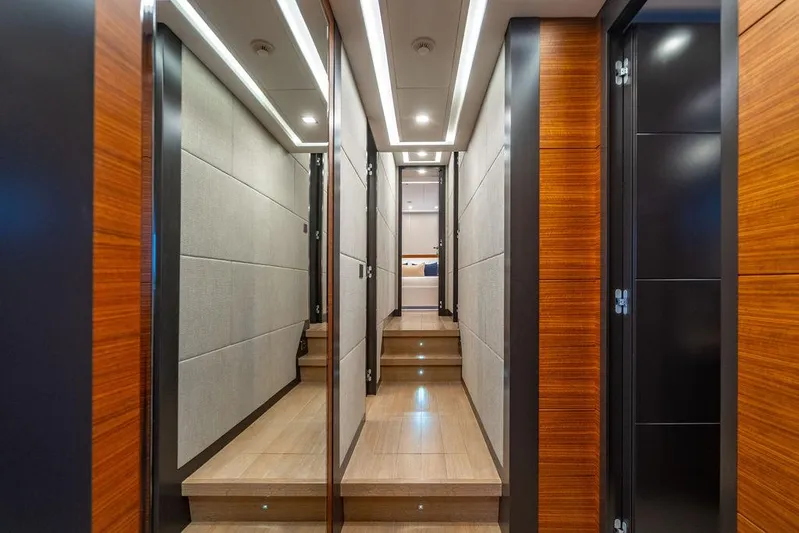 Mixed Emotions Yacht Photos Pics Luxurious interior hallway of 2014 Mangusta 110 yacht with modern wood paneling.