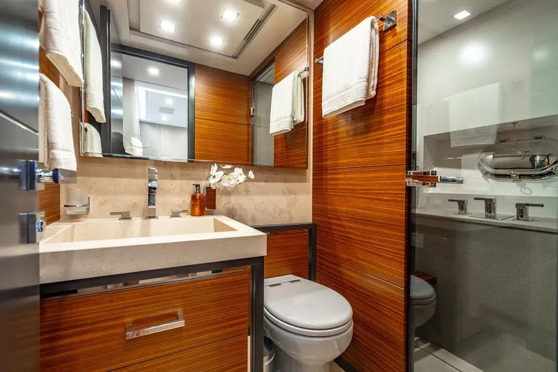 Mixed Emotions Yacht Photos Pics Luxurious bathroom in 2014 Mangusta 110 yacht, featuring wood paneling and modern fixtures.