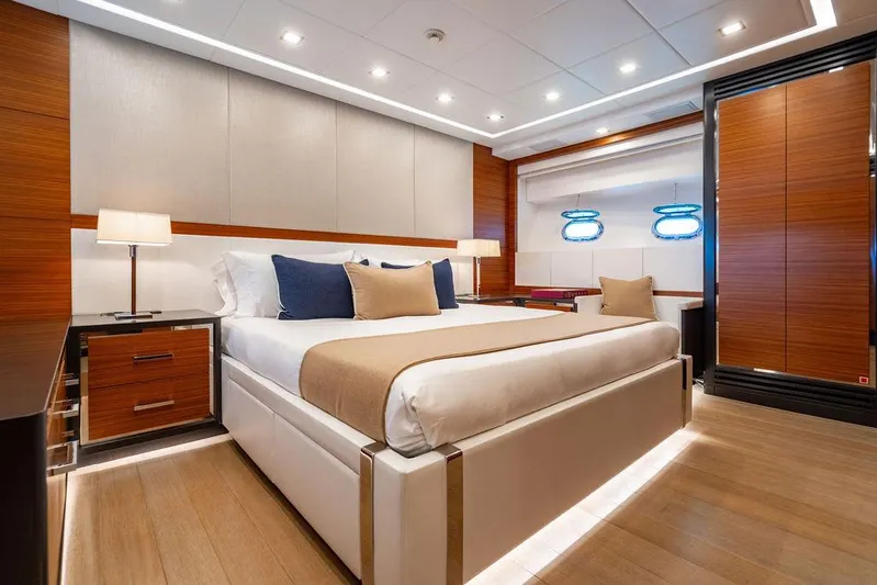 Mixed Emotions Yacht Photos Pics Luxurious bedroom interior on 2014 Mangusta 110 yacht, featuring modern design and elegant furnishings.