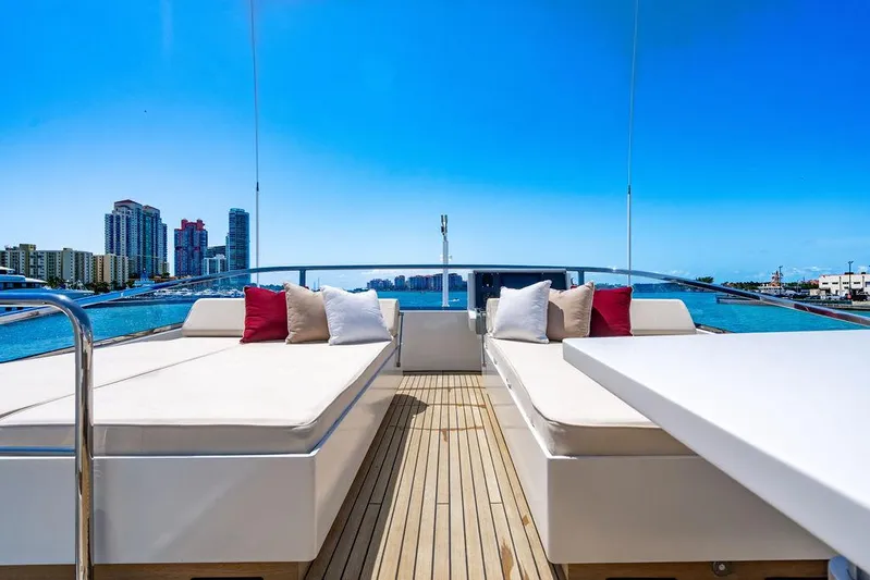 Mixed Emotions Yacht Photos Pics Luxurious 2014 Mangusta 110 yacht deck with sun loungers, city skyline view.