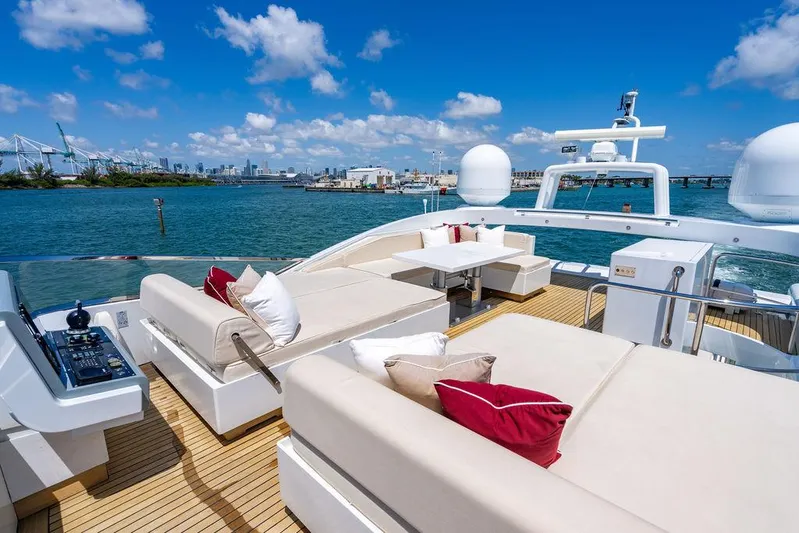 Mixed Emotions Yacht Photos Pics Luxurious 2014 Mangusta 110 yacht deck with plush seating, ocean view, and clear blue sky.