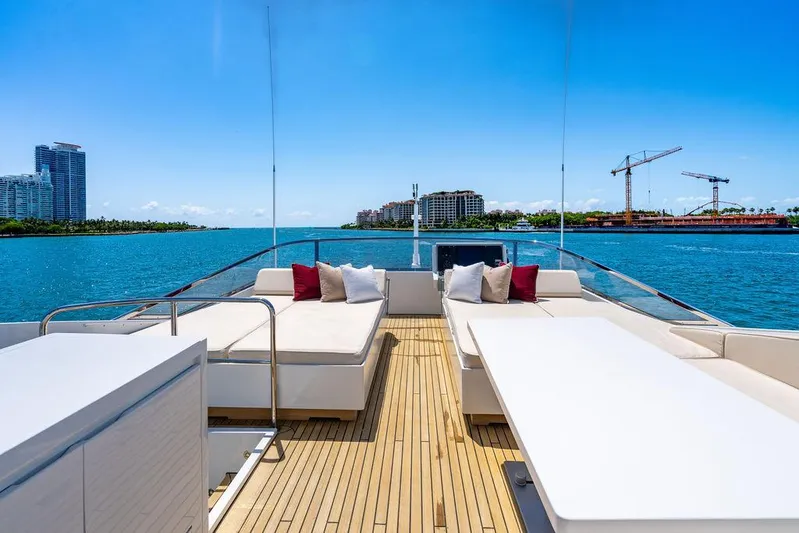 Mixed Emotions Yacht Photos Pics Luxurious 2014 Mangusta 110 yacht deck with seating, overlooking serene waterfront and cityscape.