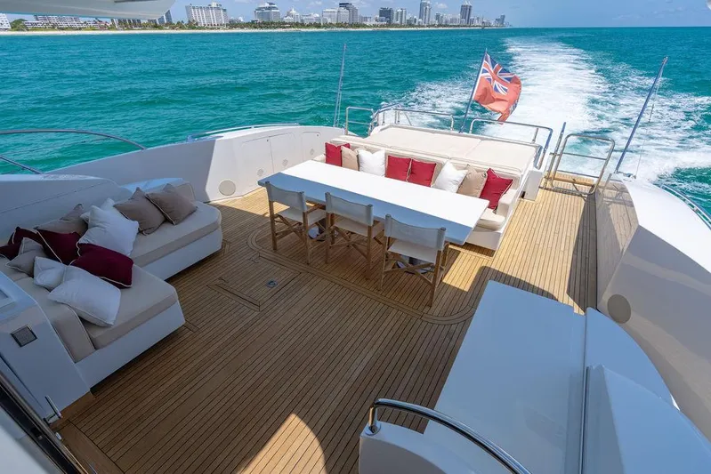 Mixed Emotions Yacht Photos Pics Luxurious 2014 Mangusta 110 yacht deck with seating, dining area, and ocean view.