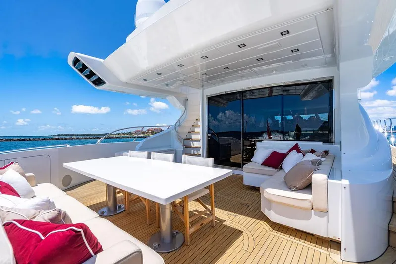 Mixed Emotions Yacht Photos Pics Luxurious 2014 Mangusta 110 yacht deck with elegant seating and dining area, ocean view.