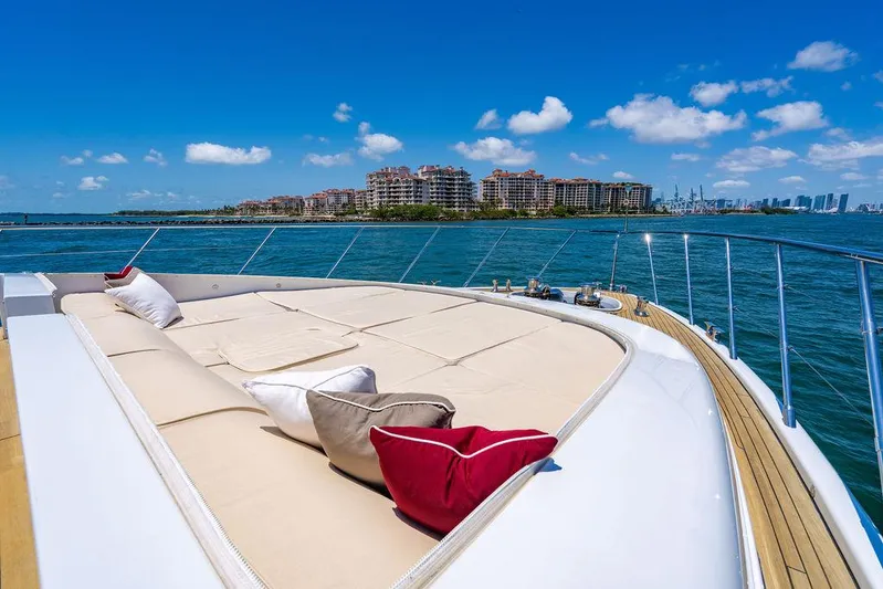 Mixed Emotions Yacht Photos Pics Luxurious 2014 Mangusta 110 yacht deck with cushions, ocean view, and city skyline.