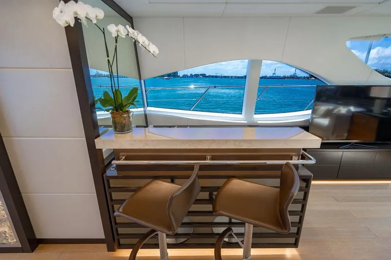 Mixed Emotions Yacht Photos Pics Luxurious interior of 2014 Mangusta 110 yacht with bar stools and ocean view.