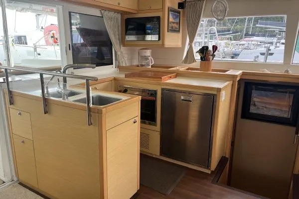 Searching For Bliss Yacht Photos Pics Modern kitchen interior of 2011 Lagoon 450 F yacht with appliances and wooden cabinetry.