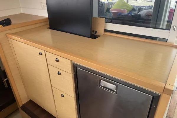 Searching For Bliss Yacht Photos Pics Interior of 2011 Lagoon 450 F yacht with wooden cabinetry and built-in appliances.