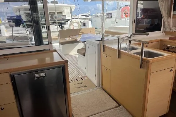 Searching For Bliss Yacht Photos Pics Interior view of 2011 Lagoon 450 F catamaran, featuring kitchen and outdoor seating area.