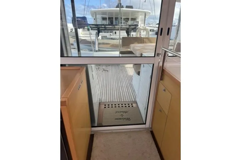 Searching For Bliss Yacht Photos Pics Interior view of 2011 Lagoon 450 F catamaran, featuring sliding glass door and wooden cabinetry.