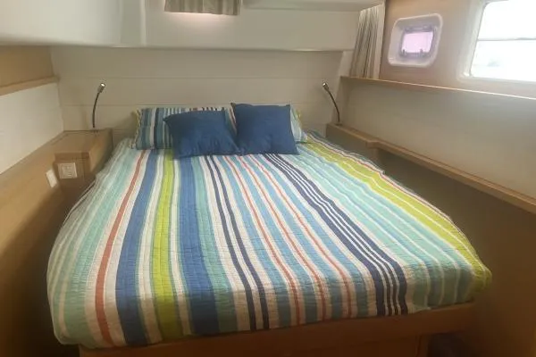 Searching For Bliss Yacht Photos Pics Interior cabin of 2011 Lagoon 450 F with striped bedding and pillows.