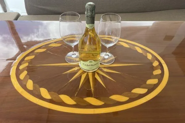 Searching For Bliss Yacht Photos Pics Bottle of white wine with glasses on a decorative wooden table aboard Lagoon 450 F, 2011.