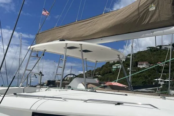 Searching For Bliss Yacht Photos Pics 2011 Lagoon 450 F catamaran docked, featuring sails and American flag, under clear blue sky.