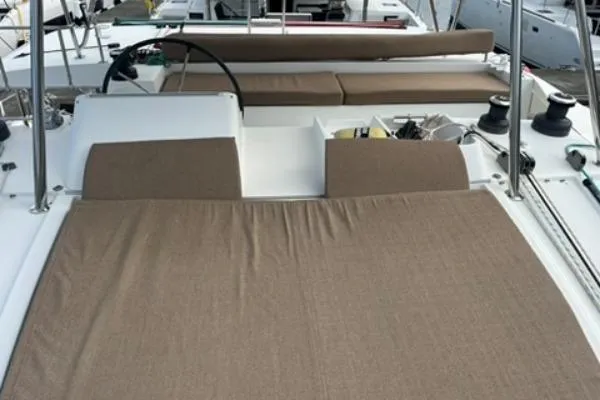 Searching For Bliss Yacht Photos Pics 2011 Lagoon 450 F catamaran deck with beige cushions and steering wheel.