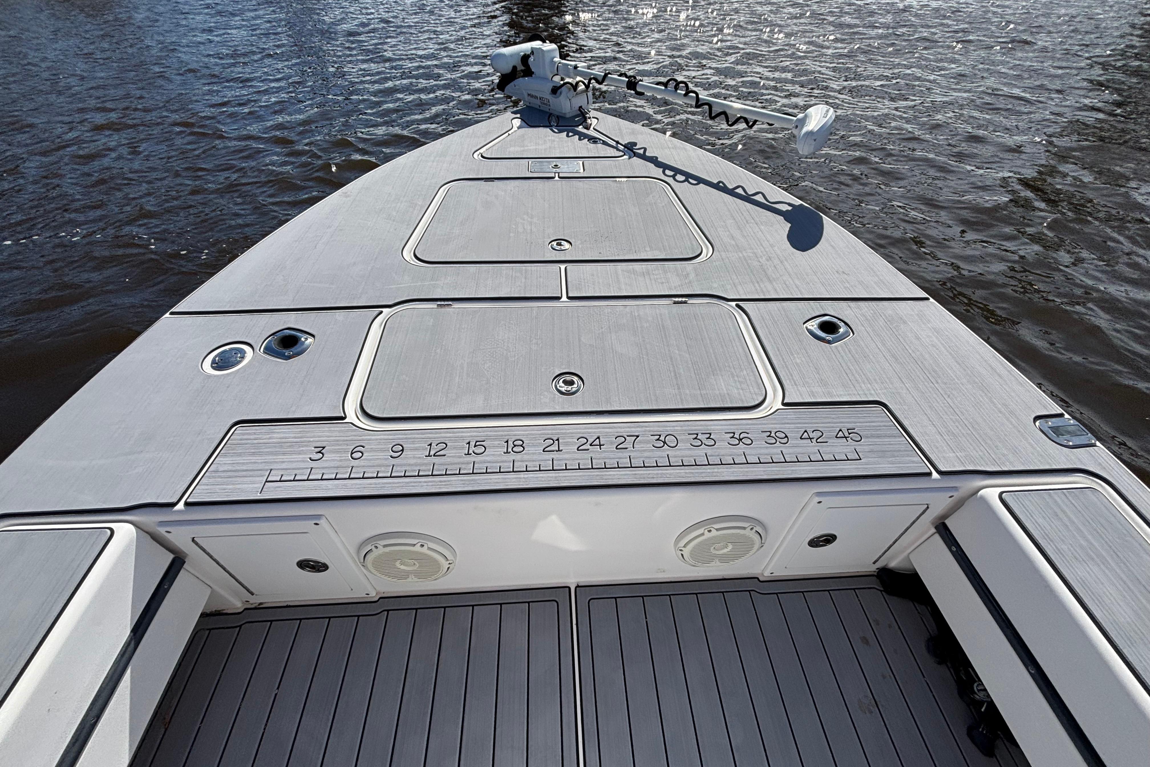 2008 Release Tarpon Bay boat deck with storage compartments and fishing ruler on calm water.