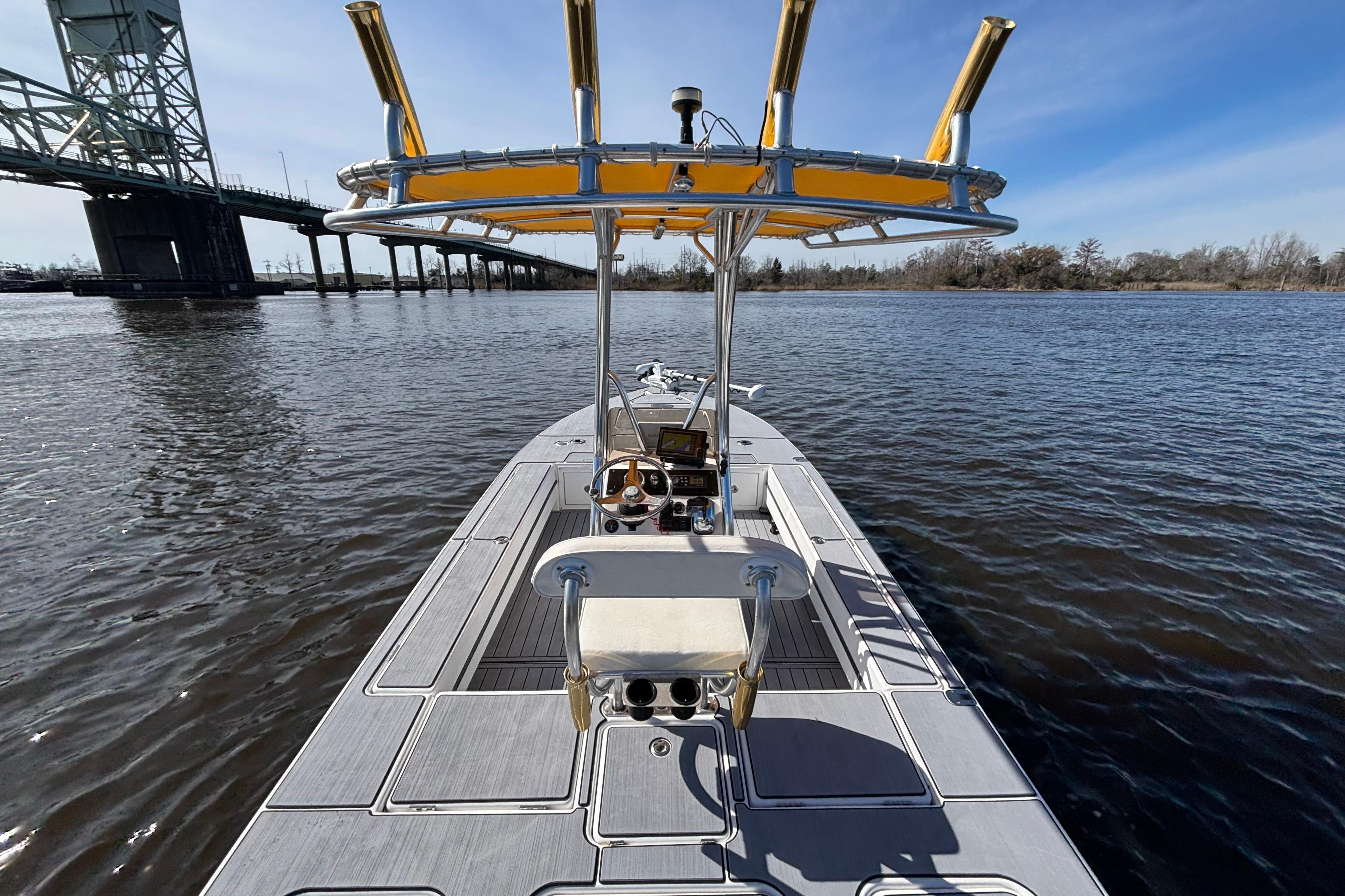 2008 Release Tarpon Bay boat on water near a bridge under clear blue sky.