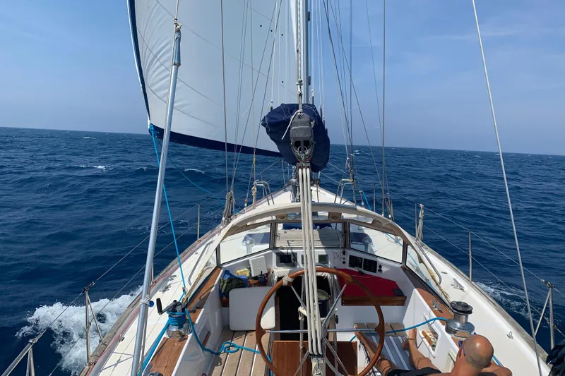 Arma Di Re Yacht Photos Pics Sailing on a 1983 Hallberg-Rassy 42E yacht in open sea under clear skies.