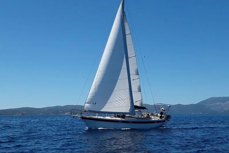 Arma Di Re Yacht Photos Pics 1983 Hallberg-Rassy 42E sailboat cruising on open sea under clear blue sky.