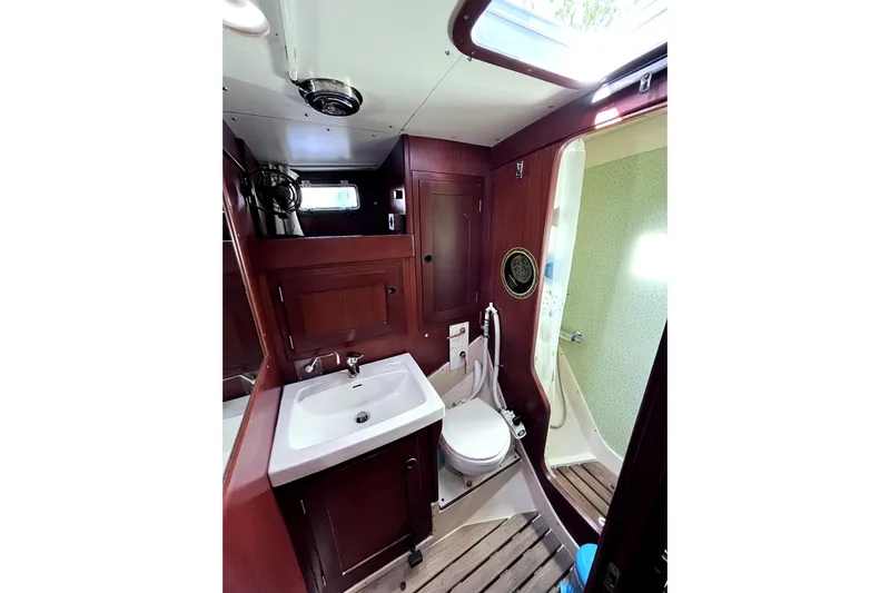 Arma Di Re Yacht Photos Pics 1983 Hallberg-Rassy 42E yacht bathroom with wooden cabinetry and modern fixtures.