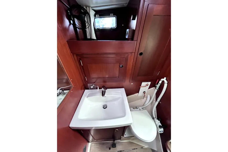 Arma Di Re Yacht Photos Pics 1983 Hallberg-Rassy 42E yacht bathroom with sink, toilet, and wooden cabinetry.