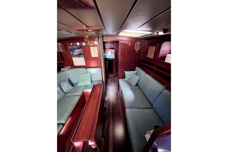 Arma Di Re Yacht Photos Pics Interior of 1983 Hallberg-Rassy 42E yacht with cozy seating and wooden finishes.