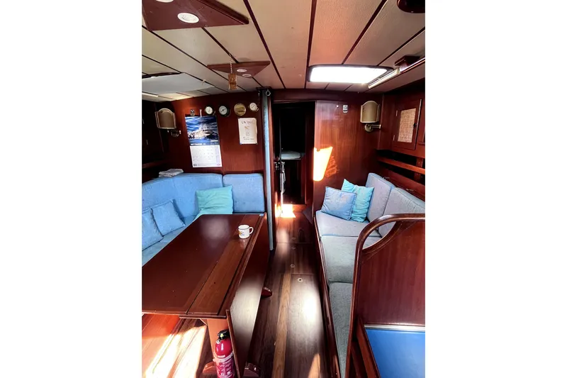 Arma Di Re Yacht Photos Pics Interior of 1983 Hallberg-Rassy 42E sailboat with cozy seating and wooden finishes.