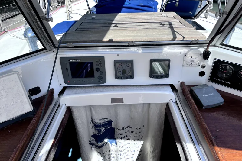 Arma Di Re Yacht Photos Pics Cockpit of 1983 Hallberg-Rassy 42E sailboat with navigation instruments and wooden accents.
