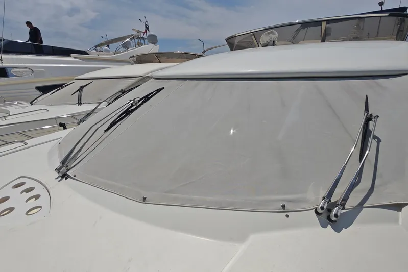  Yacht Photos Pics 2001 Sunseeker Manhattan 74 yacht with covered windshield and wipers, docked under clear skies.
