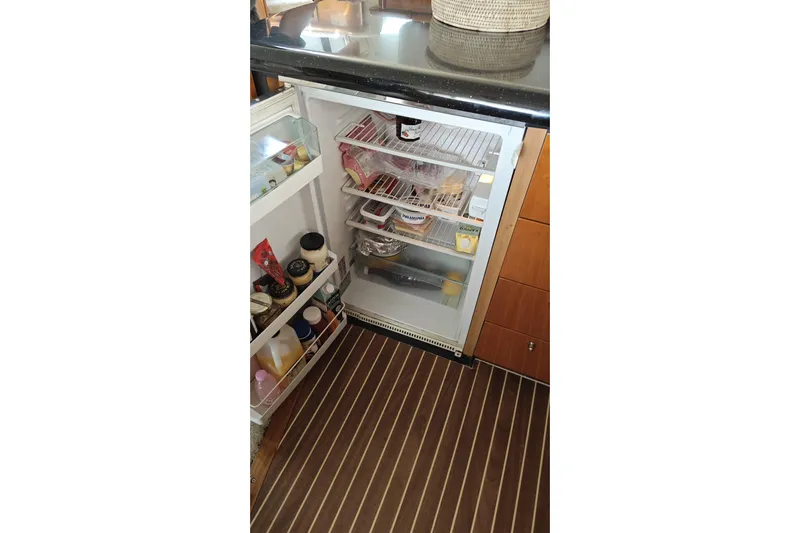  Yacht Photos Pics Open refrigerator in Sunseeker Manhattan 74 yacht, stocked with various food items.