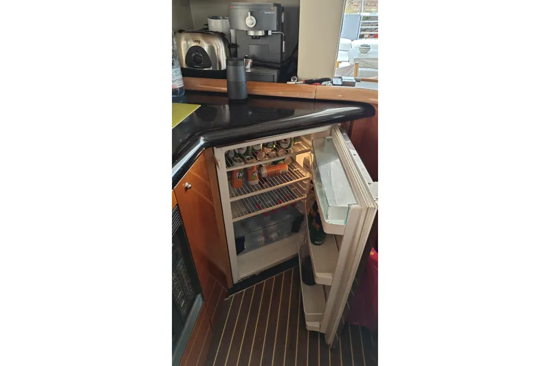  Yacht Photos Pics Open fridge in 2001 Sunseeker Manhattan 74 yacht kitchen with drinks and appliances.