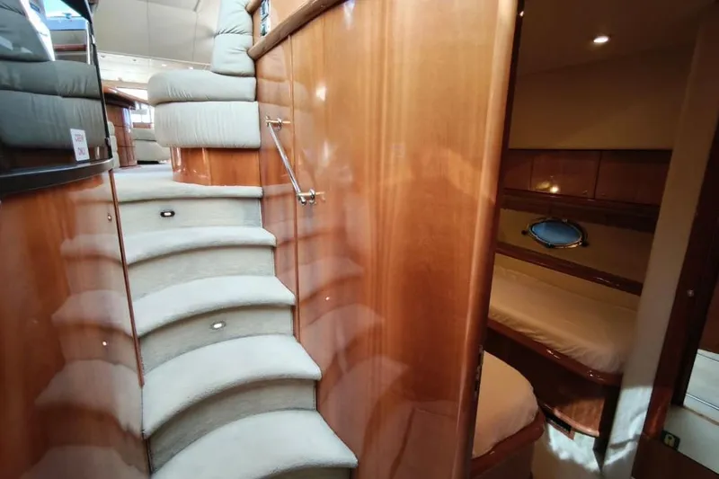  Yacht Photos Pics Luxurious interior of 2001 Sunseeker Manhattan 74 yacht with elegant wooden staircase and cozy cabin.