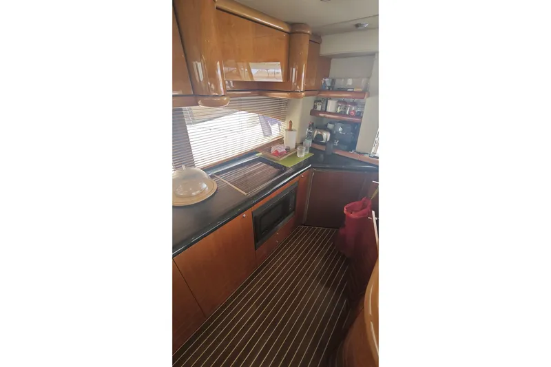  Yacht Photos Pics Luxurious kitchen interior of 2001 Sunseeker Manhattan 74 yacht with wooden cabinetry.