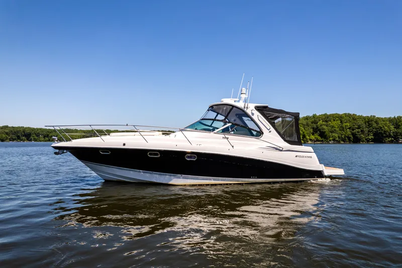 Four Fans Yacht Photos Pics 2008 Four Winns V378 boat on calm water under clear blue sky.