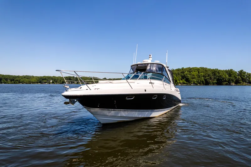 Four Fans Yacht Photos Pics 2008 Four Winns V378 yacht cruising on a serene lake under a clear blue sky.