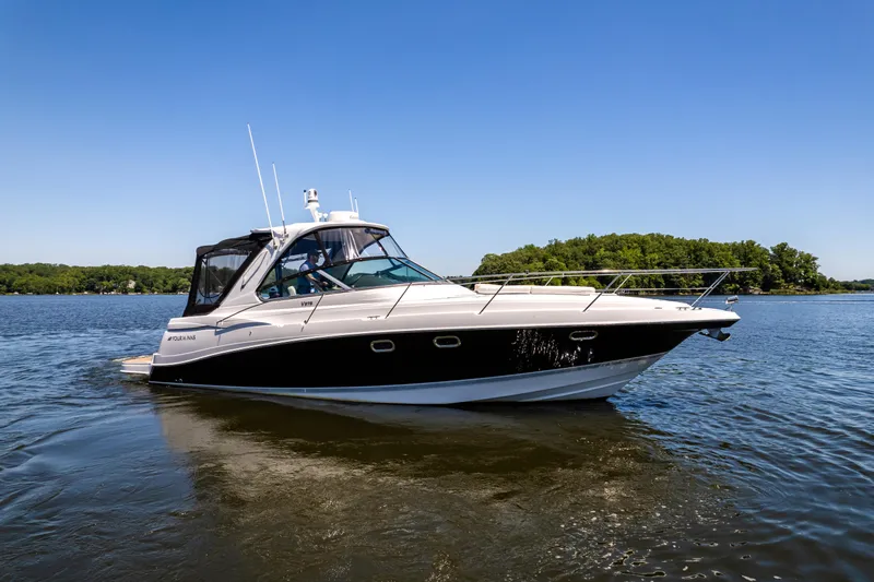 Four Fans Yacht Photos Pics 2008 Four Winns V378 boat cruising on a calm lake under a clear blue sky.