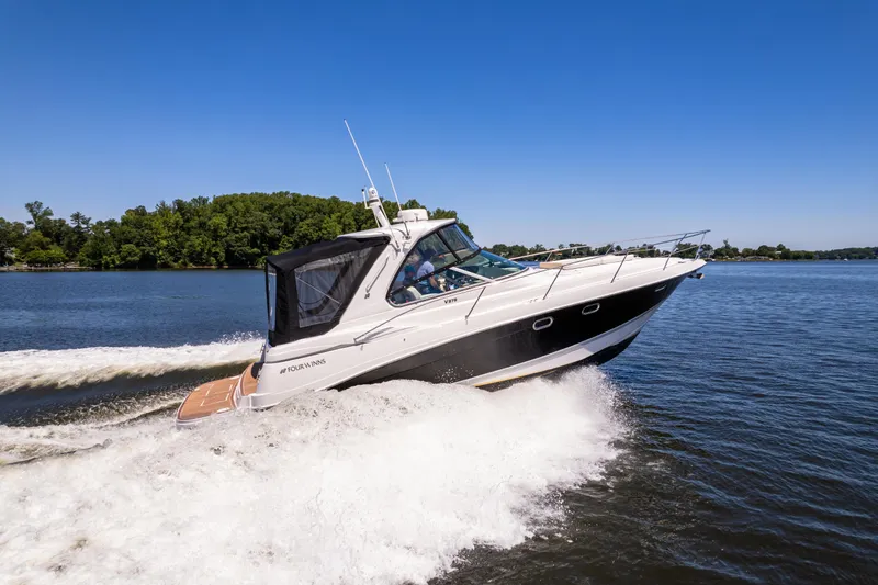 Four Fans Yacht Photos Pics 2008 Four Winns V378 boat cruising on a lake with lush green shoreline.