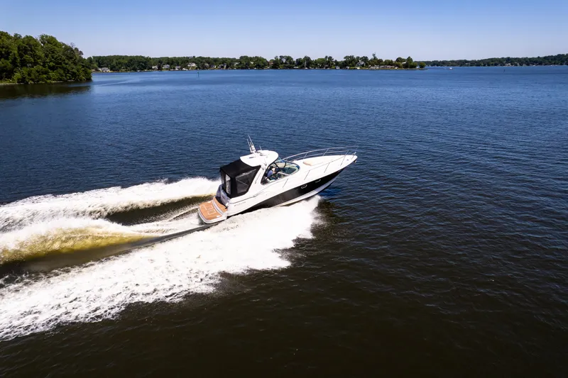 Four Fans Yacht Photos Pics 2008 Four Winns V378 boat cruising on a lake under clear blue skies.