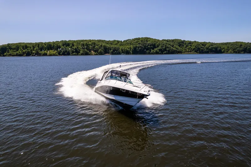 Four Fans Yacht Photos Pics 2008 Four Winns V378 boat cruising on a lake with lush green shoreline.