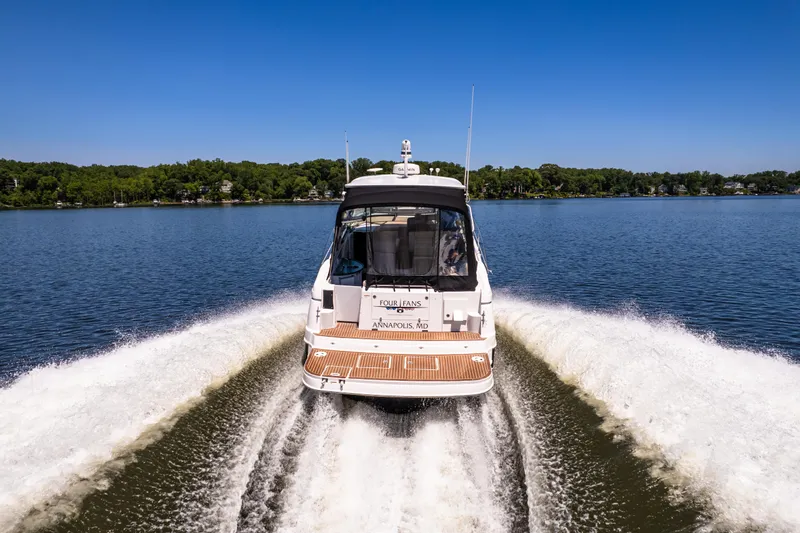 Four Fans Yacht Photos Pics 2008 Four Winns V378 boat cruising on a lake with a clear blue sky.