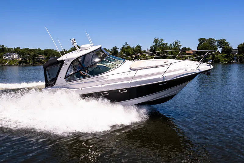 Four Fans Yacht Photos Pics 2008 Four Winns V378 boat cruising on a lake with trees in the background.
