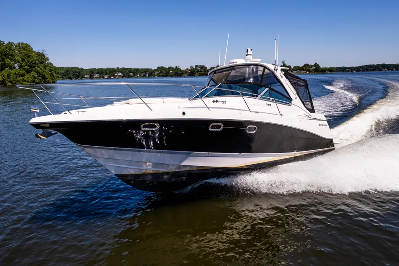 Four Fans Yacht Photos Pics 2008 Four Winns V378 boat cruising on a sunny day, creating a wake.