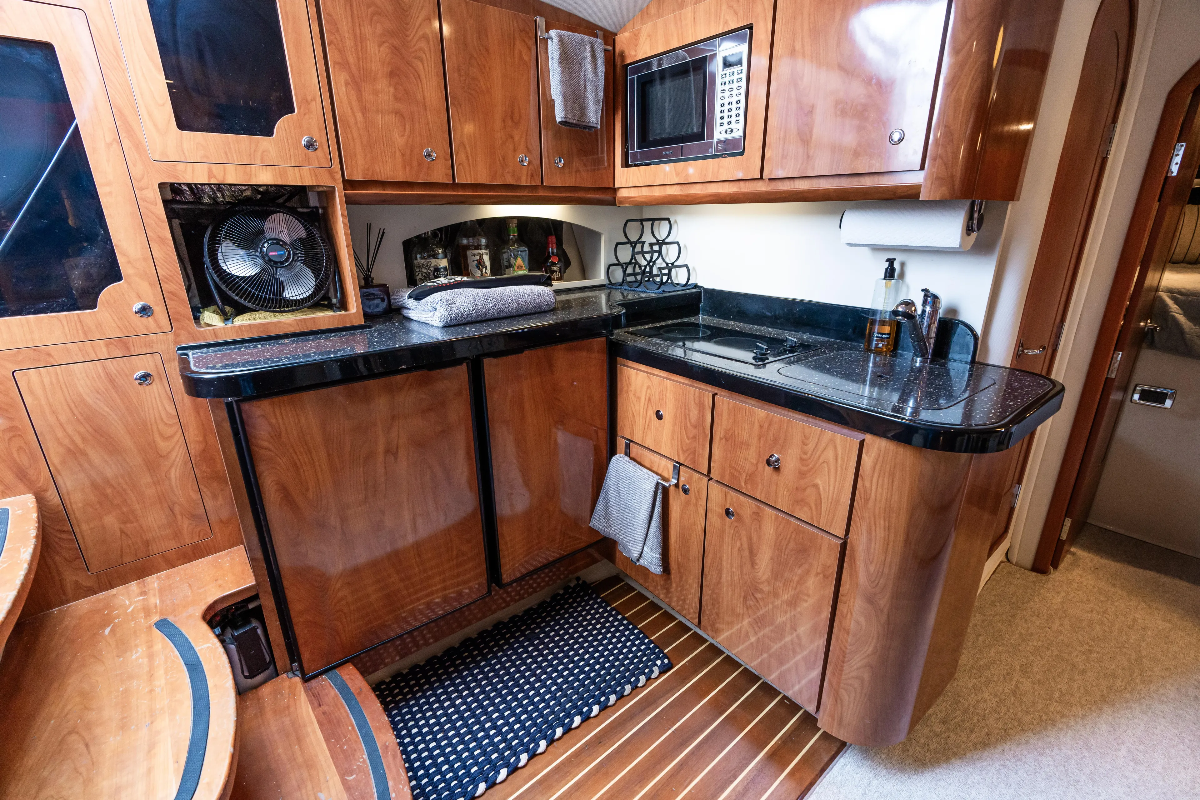 Four Fans Yacht Photos Pics 2008 Four Winns V378 yacht kitchen with wooden cabinets and modern appliances.