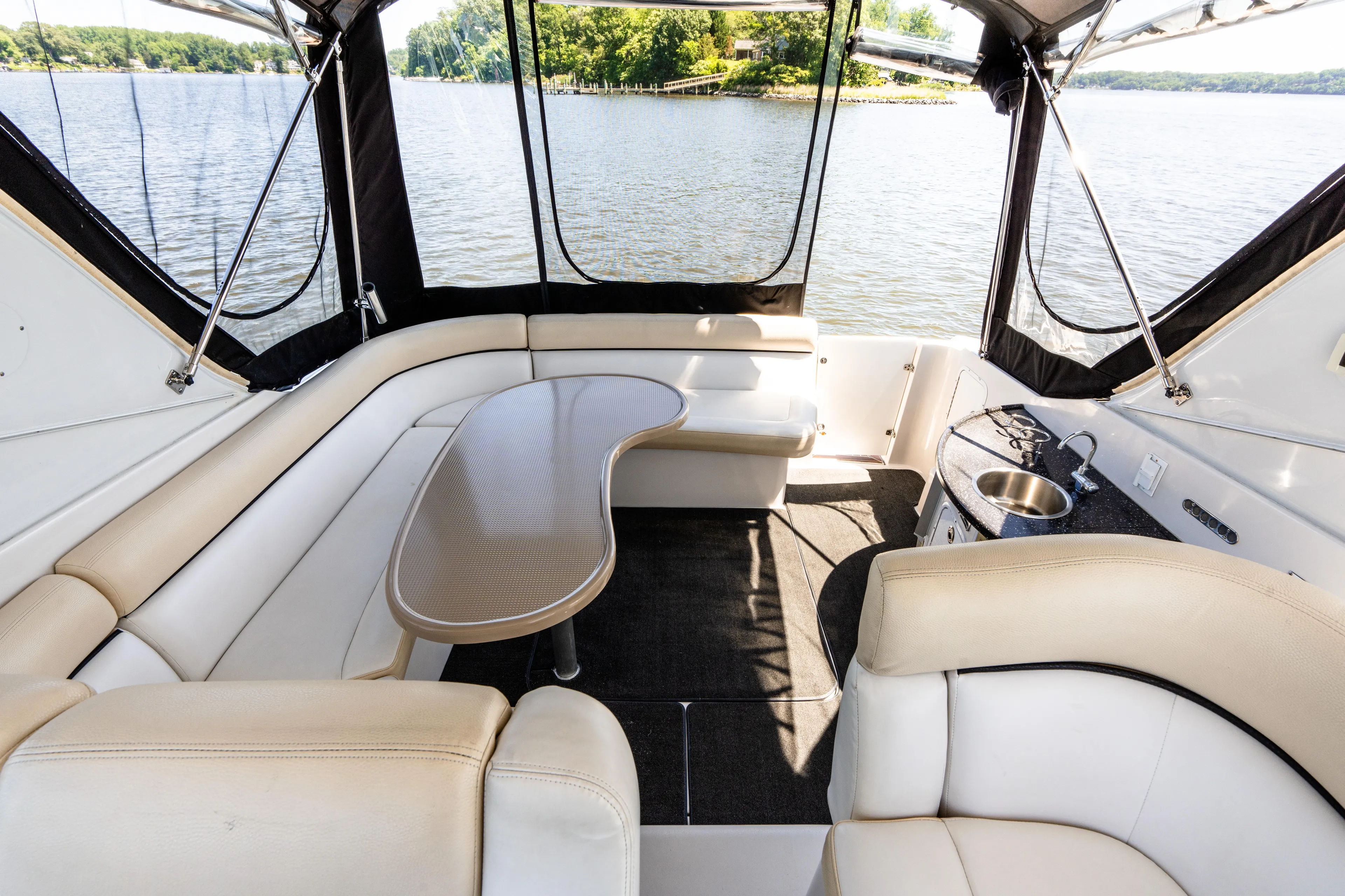 Four Fans Yacht Photos Pics Luxurious 2008 Four Winns V378 yacht interior with seating and table, overlooking serene lake.