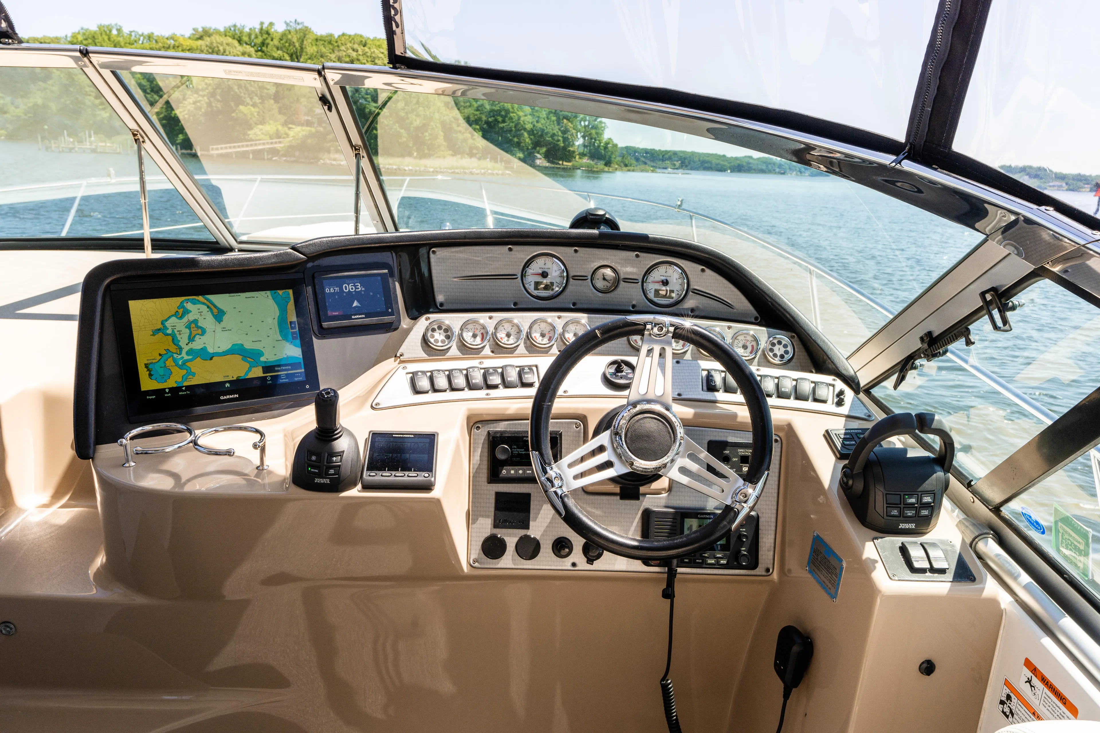 Four Fans Yacht Photos Pics 2008 Four Winns V378 boat dashboard with navigation screens and steering wheel on a sunny day.
