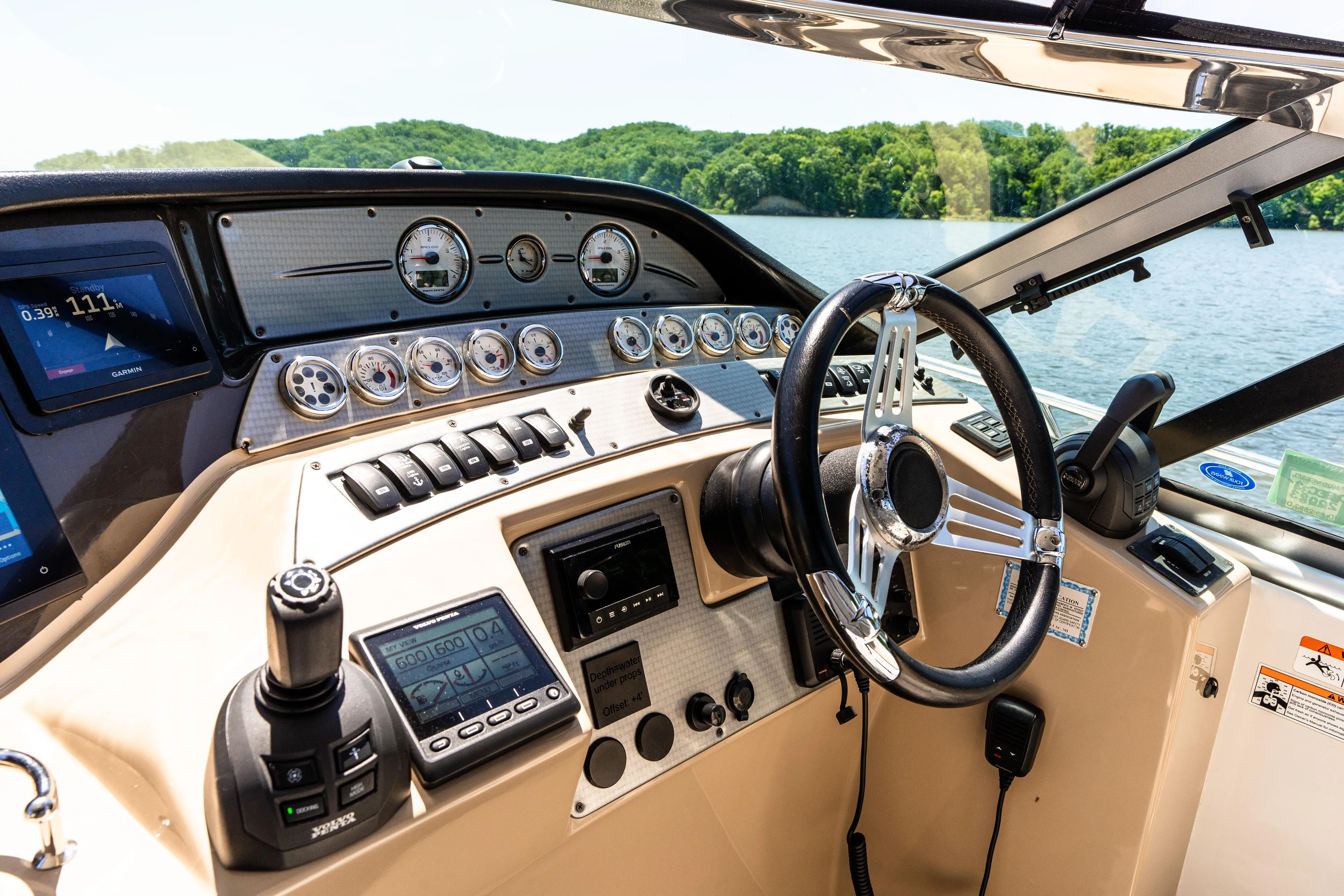 Four Fans Yacht Photos Pics 2008 Four Winns V378 boat dashboard with steering wheel and control panels on a sunny day.