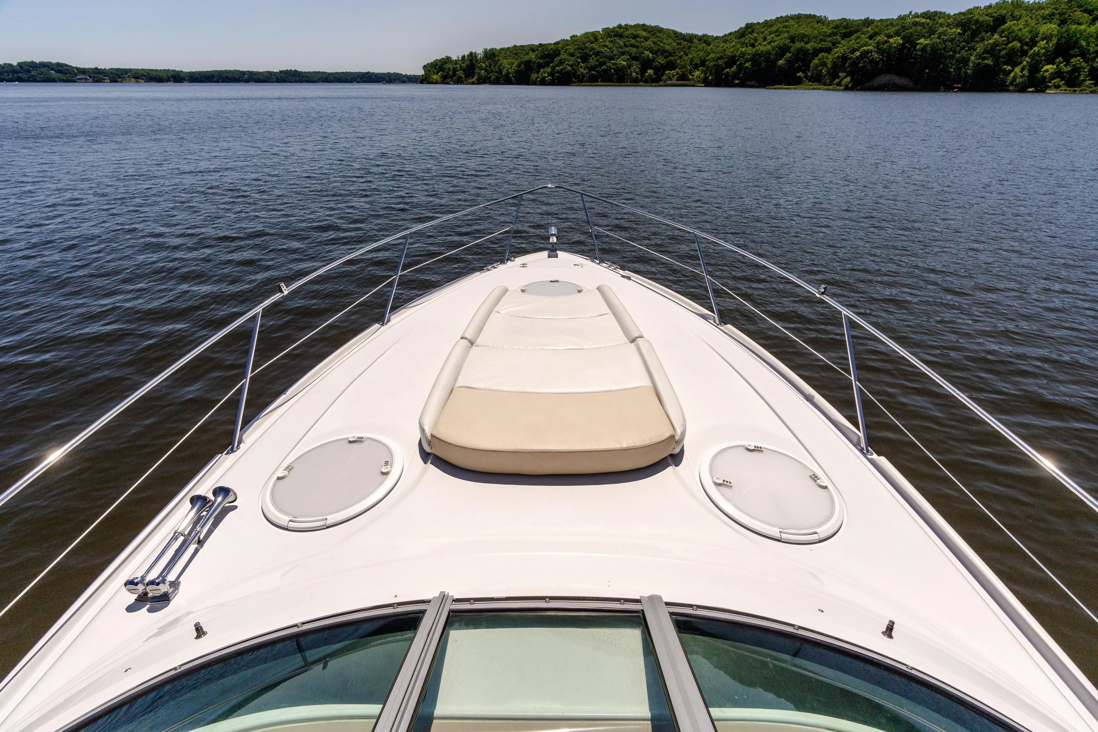 Four Fans Yacht Photos Pics 2008 Four Winns V378 yacht cruising on a calm lake with lush green shoreline.