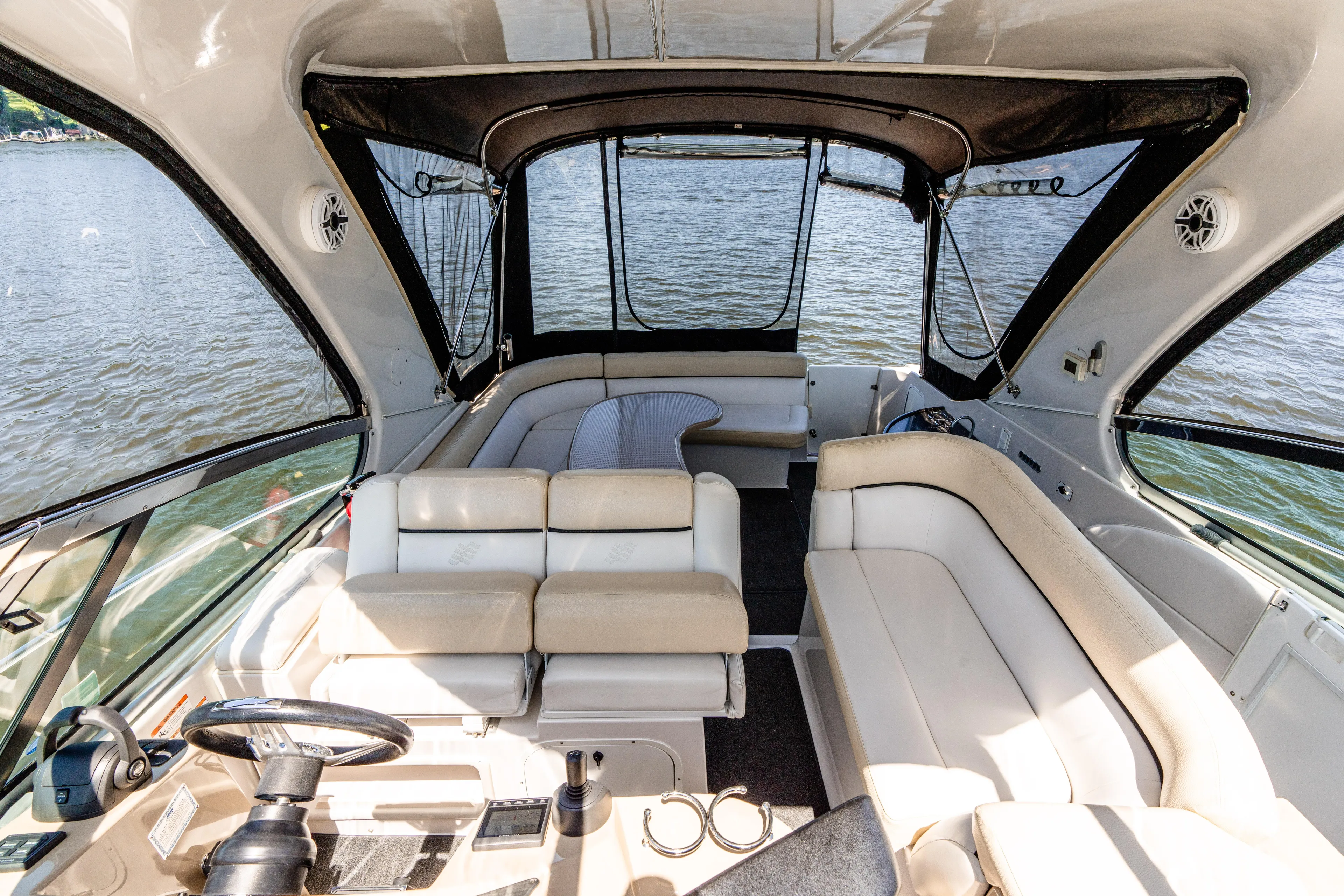 Four Fans Yacht Photos Pics 2008 Four Winns V378 boat interior with beige seating and steering, overlooking water.