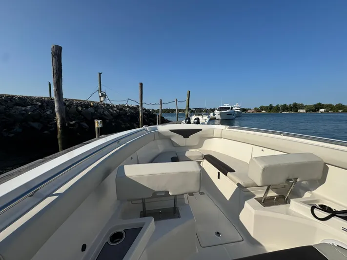  Yacht Photos Pics 2023 Sailfish 312 CC boat interior with seating, docked by a calm waterfront.